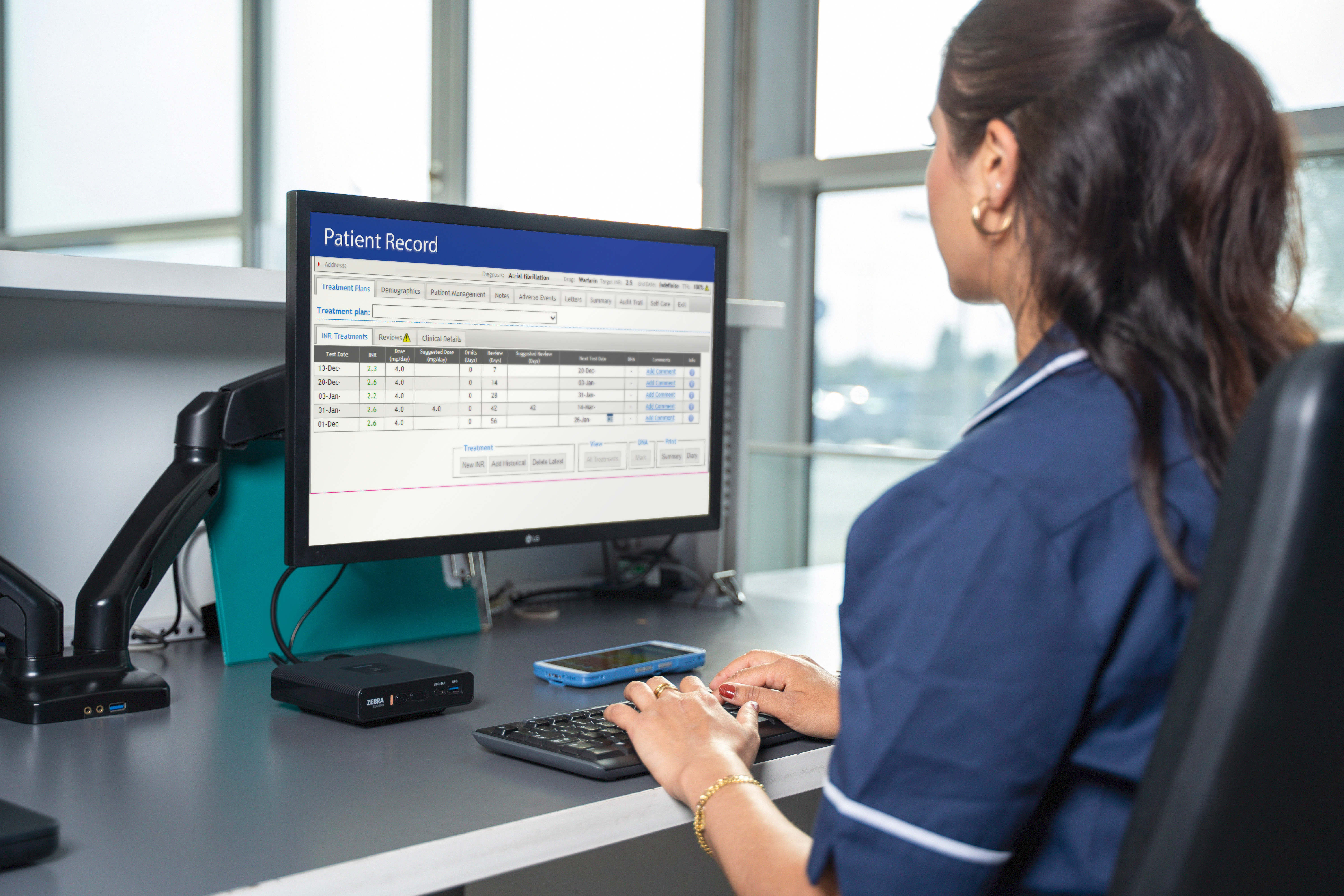 A healthcare worker using ZEC500 as a mobile workstation, HC50 is seen on the table