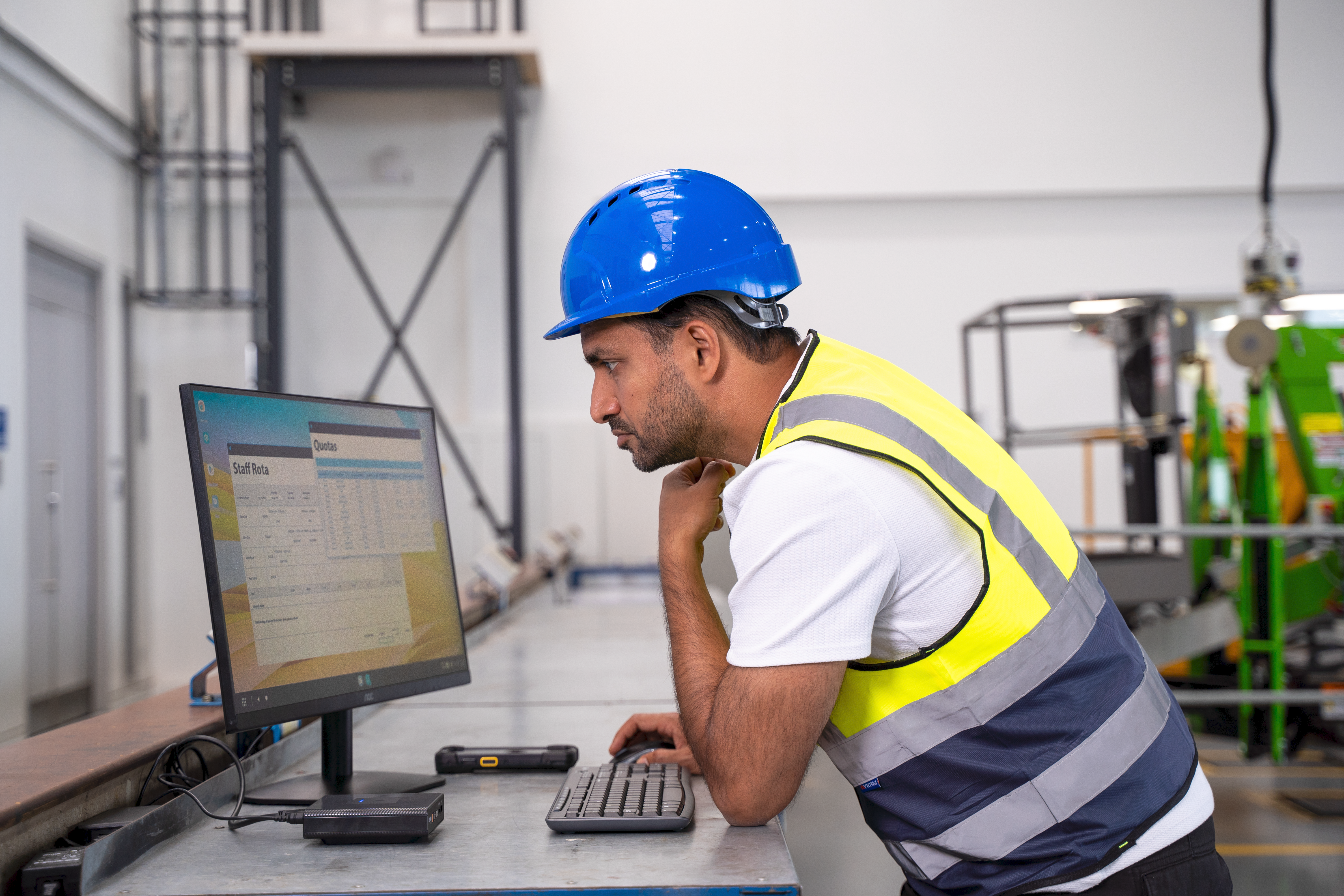 Manufacturing setting, a worker is using ZEC500 as a workstation, a TC73 is in the back