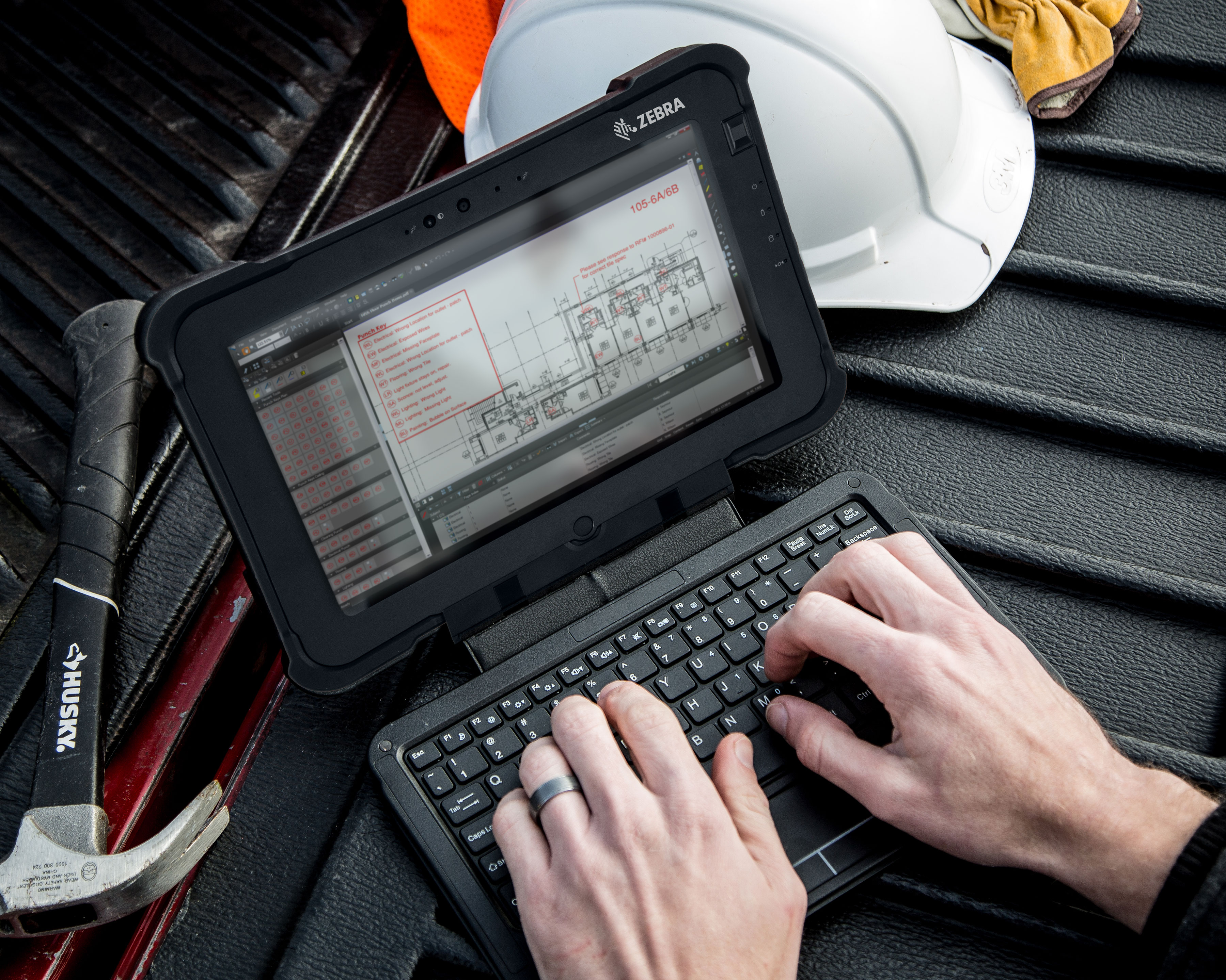 Construction worker uses a Zebra L10 rugged tablet to update a construction punch list on a truck bed