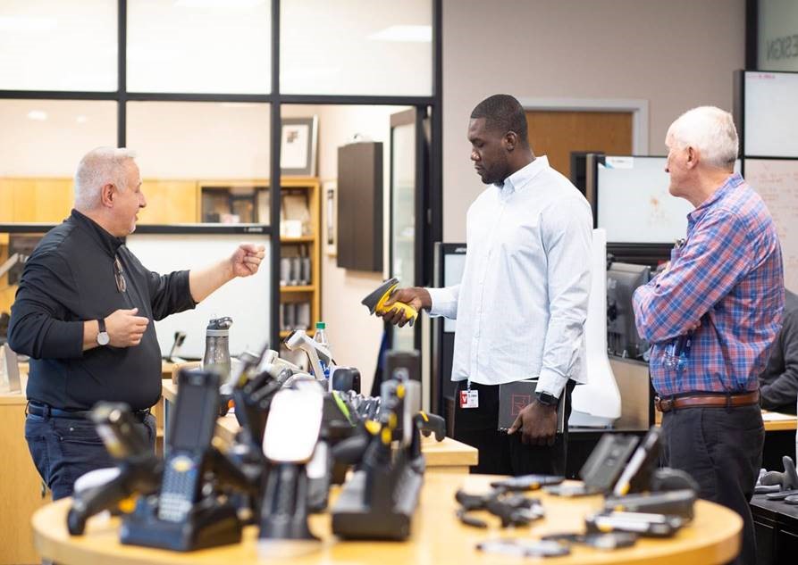 NFL defensive lineman Eric Lee get a hands-on demo of Zebra technology at the Holtsville office during hs three-week externship