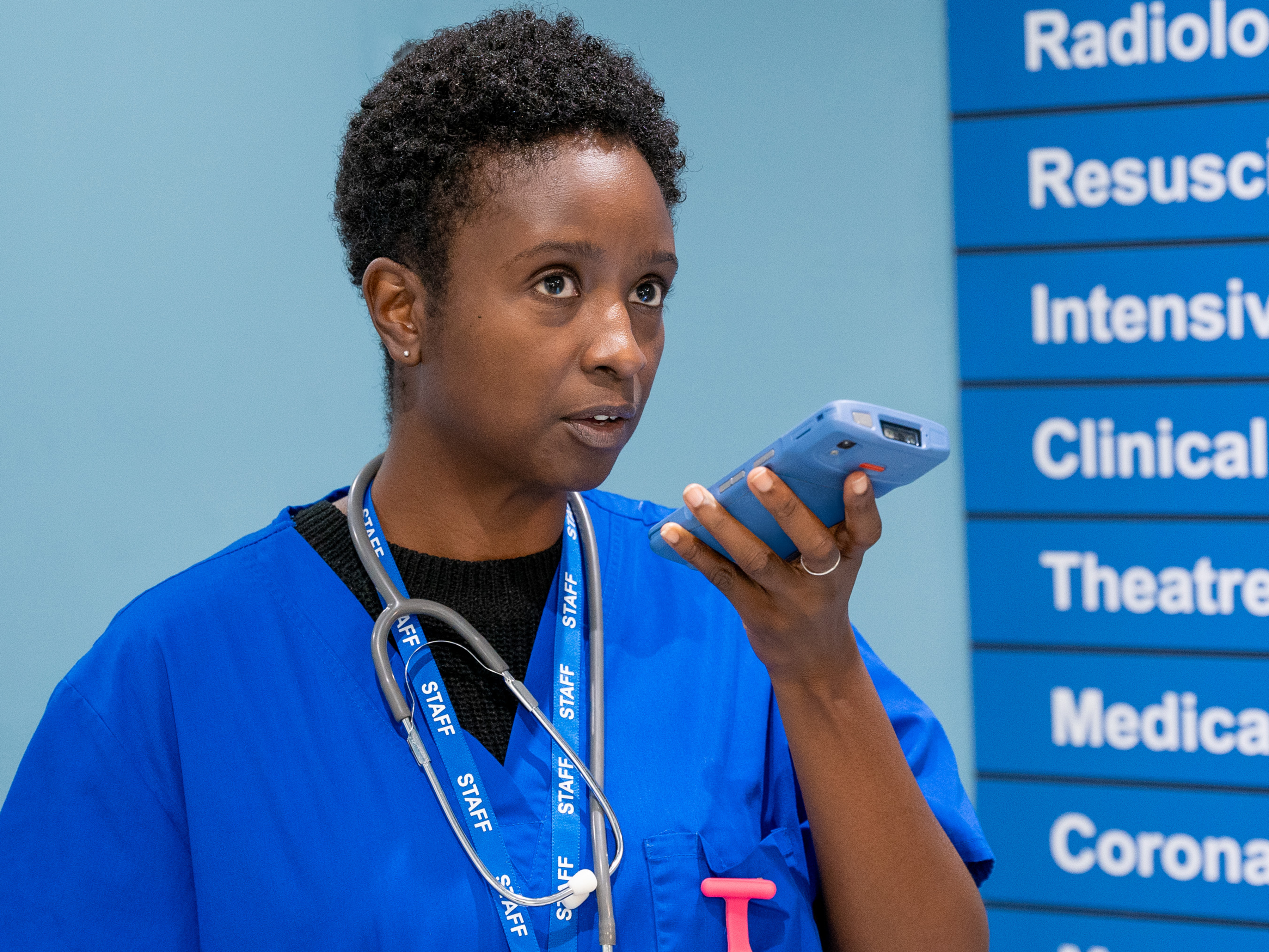 Nurse in hallway with Zebra HC50 product