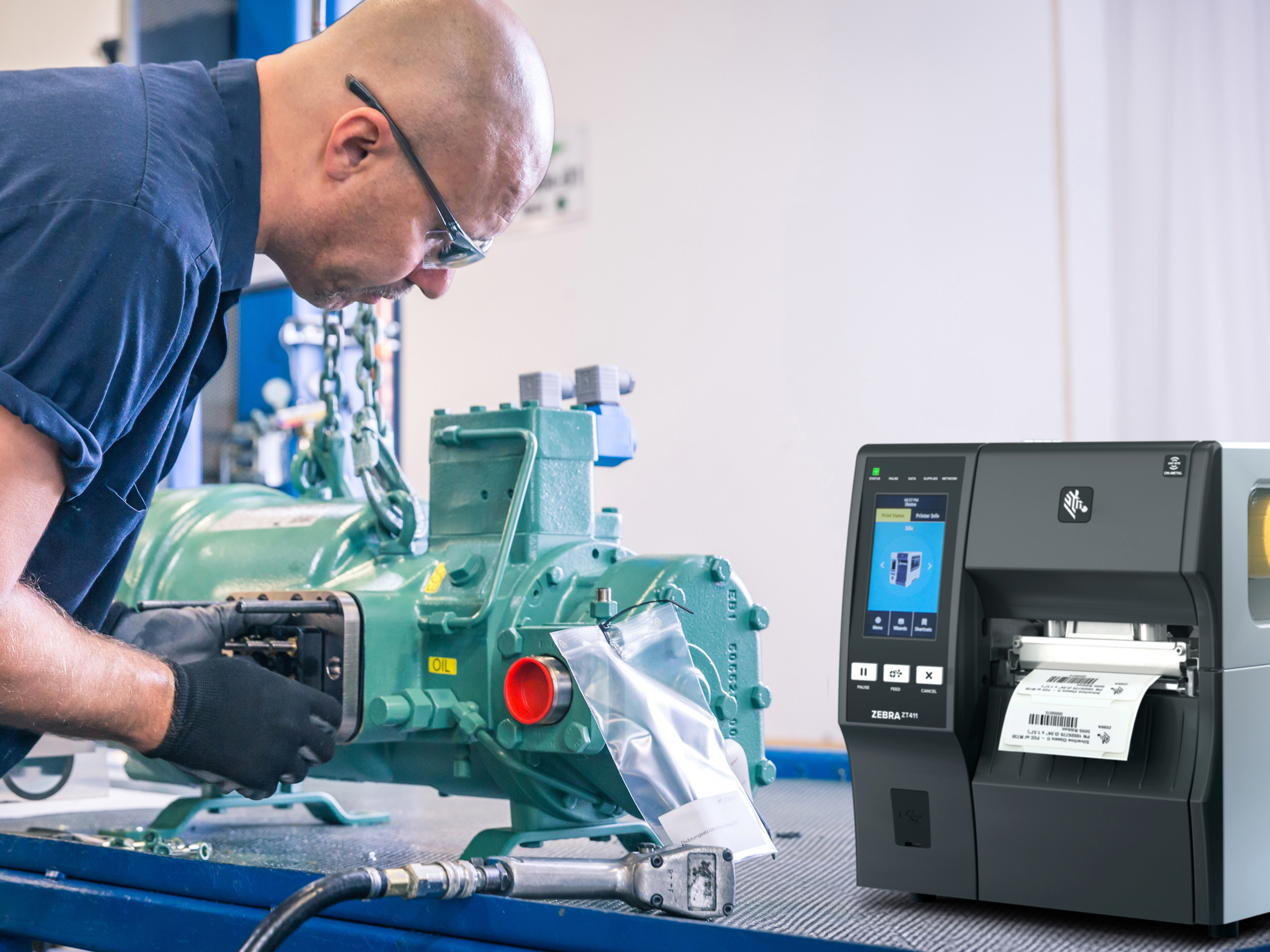 Worker using a Zebra industrial printer in a manufacturing setting. 