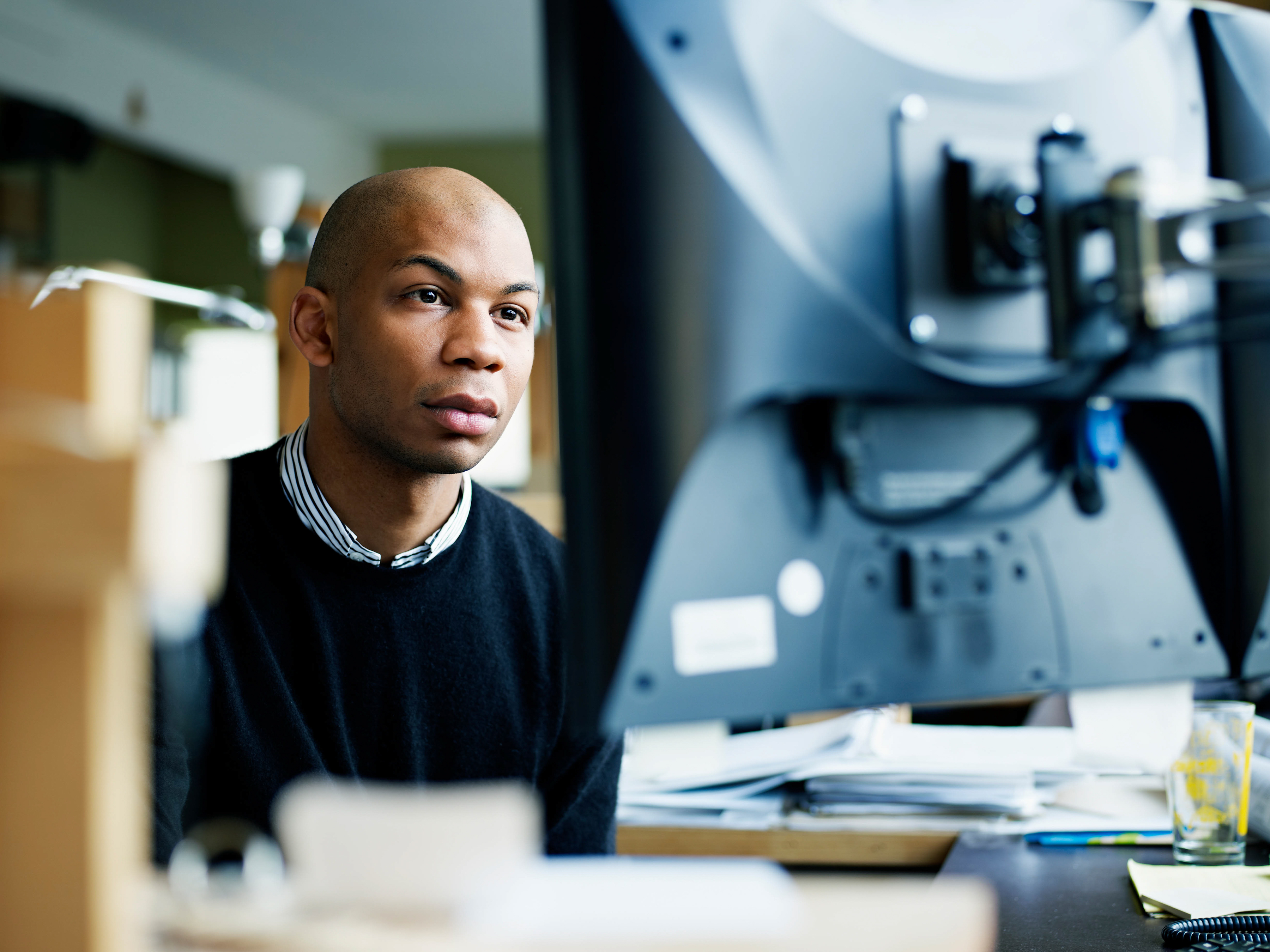 A focused employee working on a computer inside an office setting.