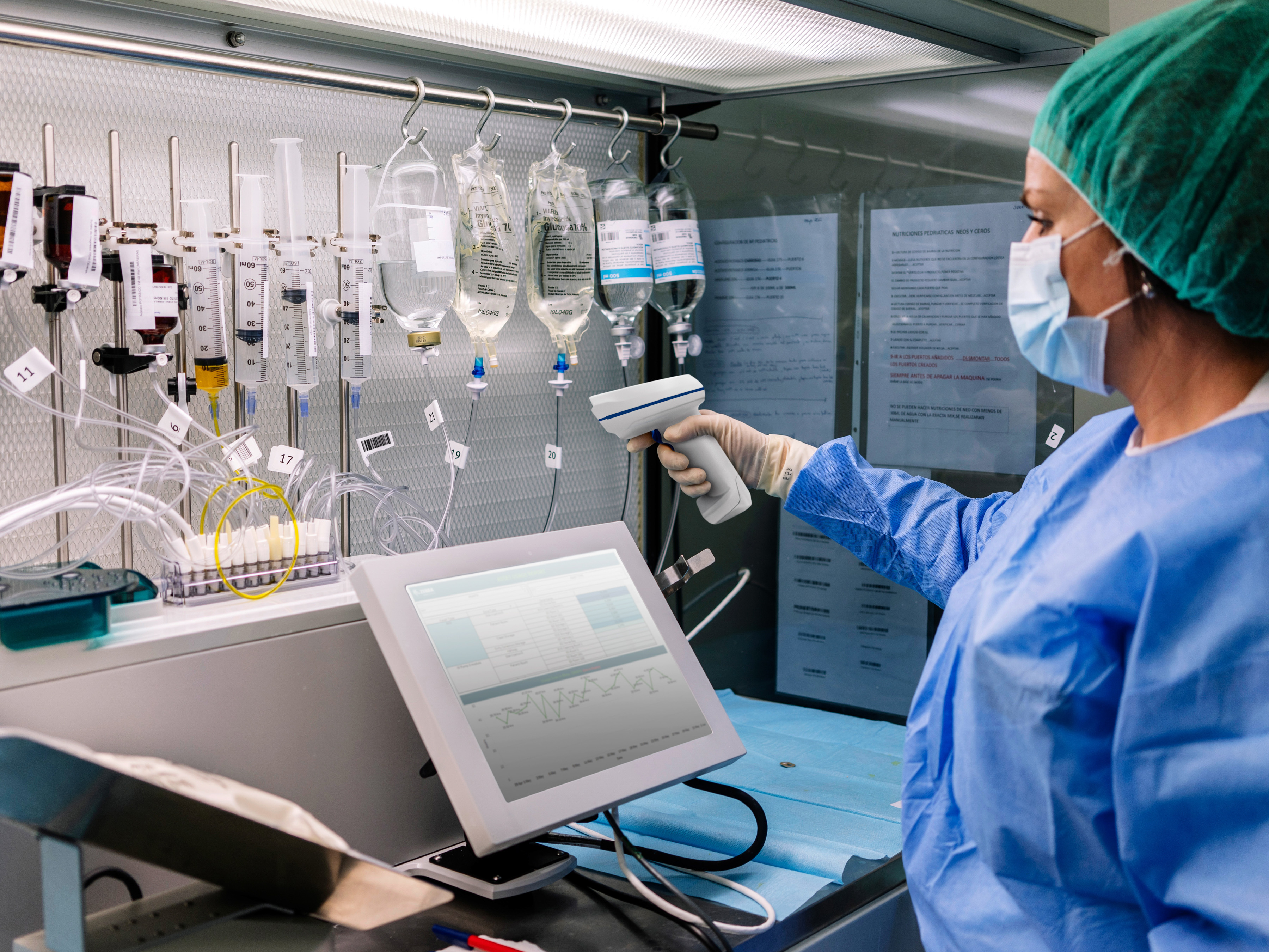 Healthcare workers using a Zebra healthcare barcode scanner to scan IV drips in a laboratory workstation.