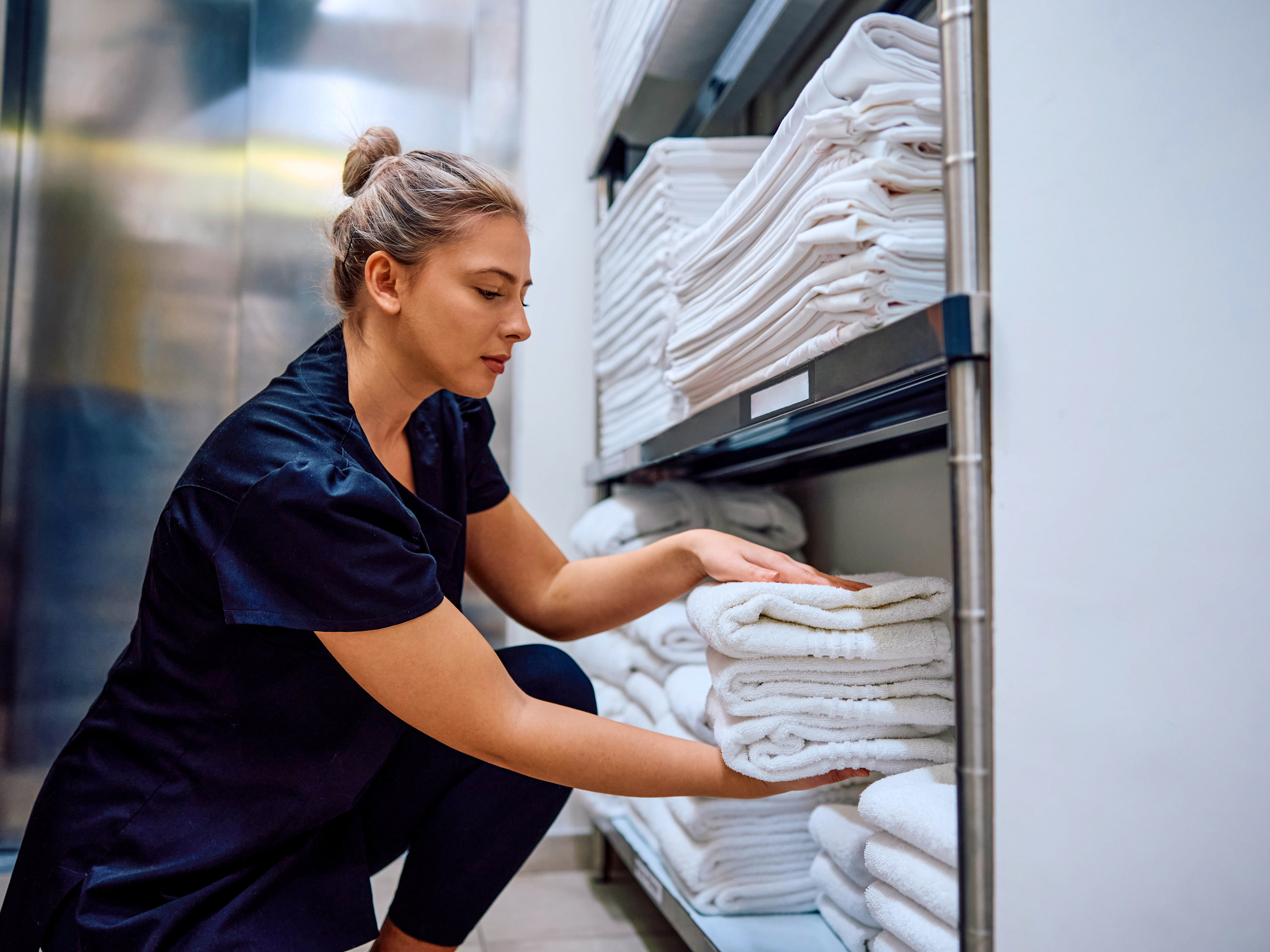 Housekeeping getting towels from a storage room inside of a hotel.