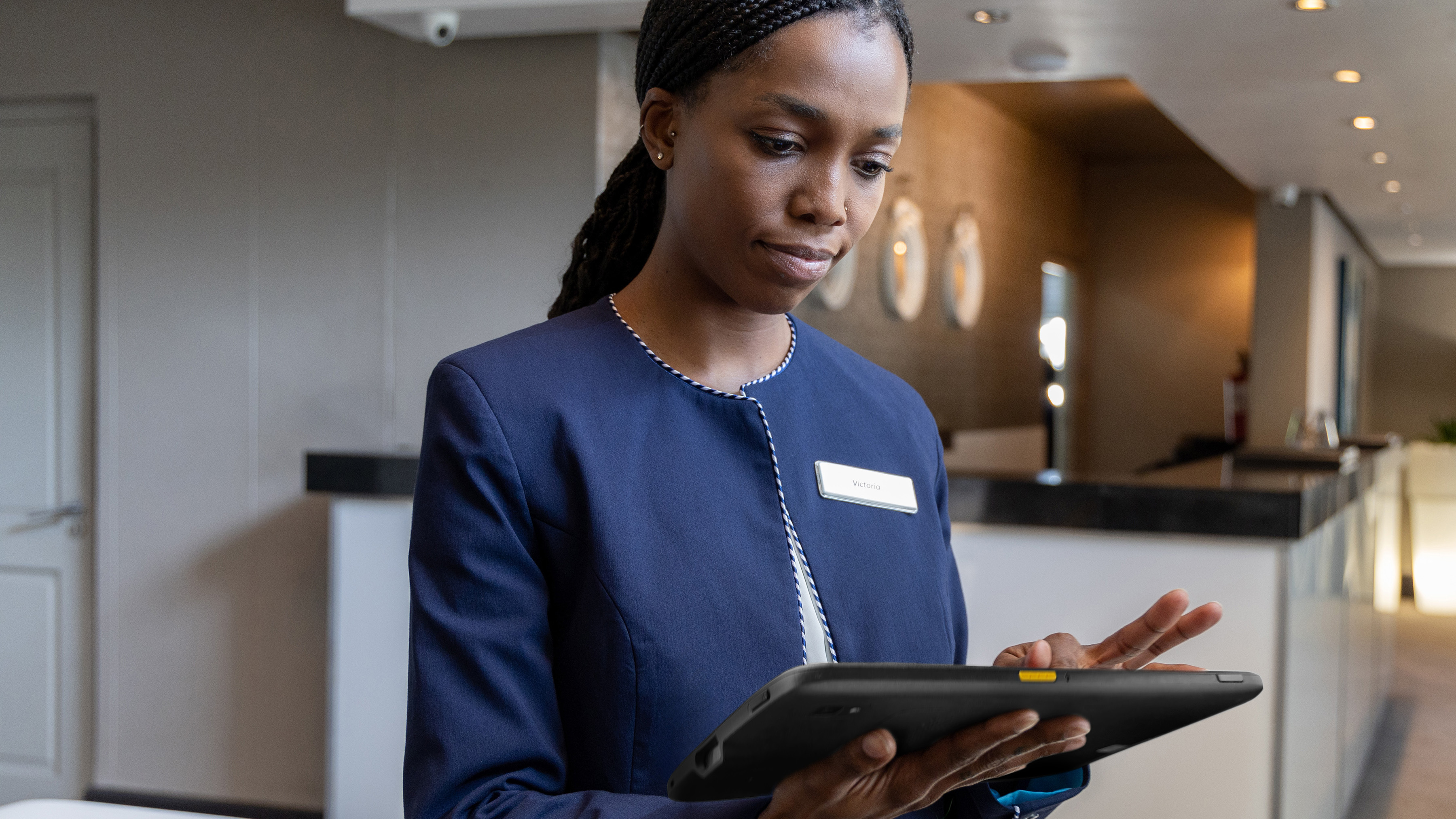 Hospitality worker using a Zebra tablet at a hotel event.