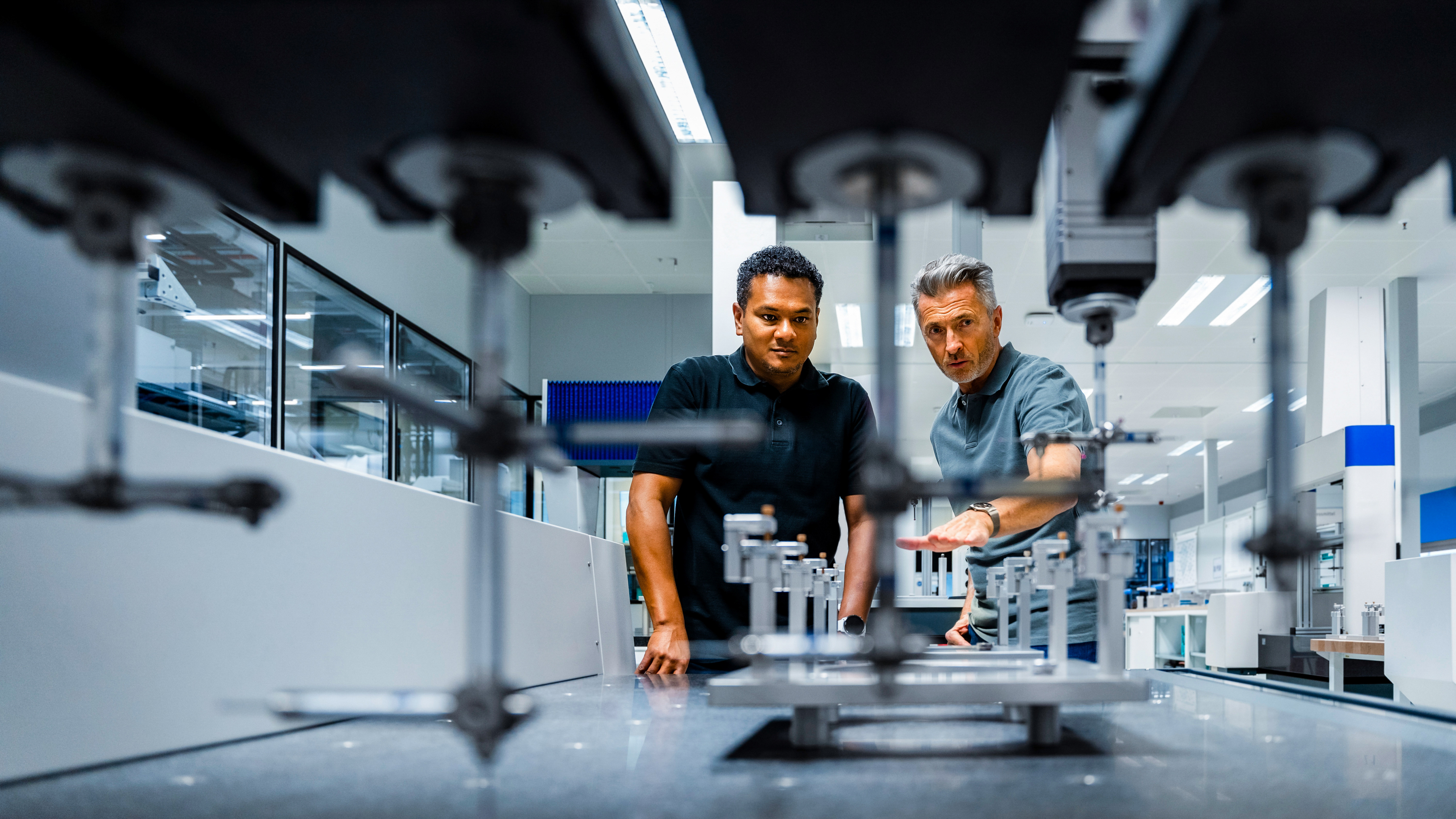 Two engineers are inspecting and discussing machinery in a modern industrial setting.