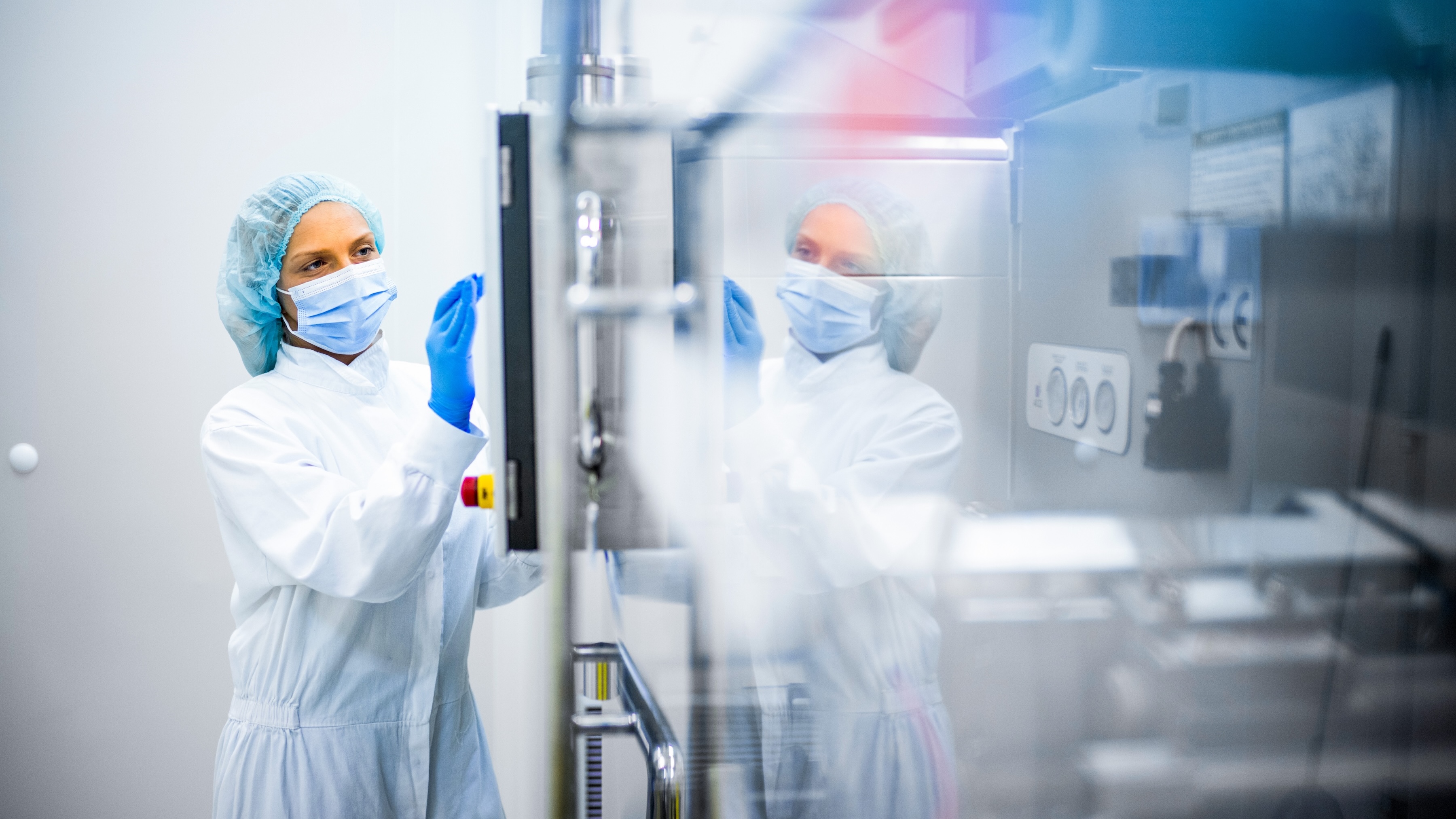 A lab is working and handling machinery in an industrial medical setting.