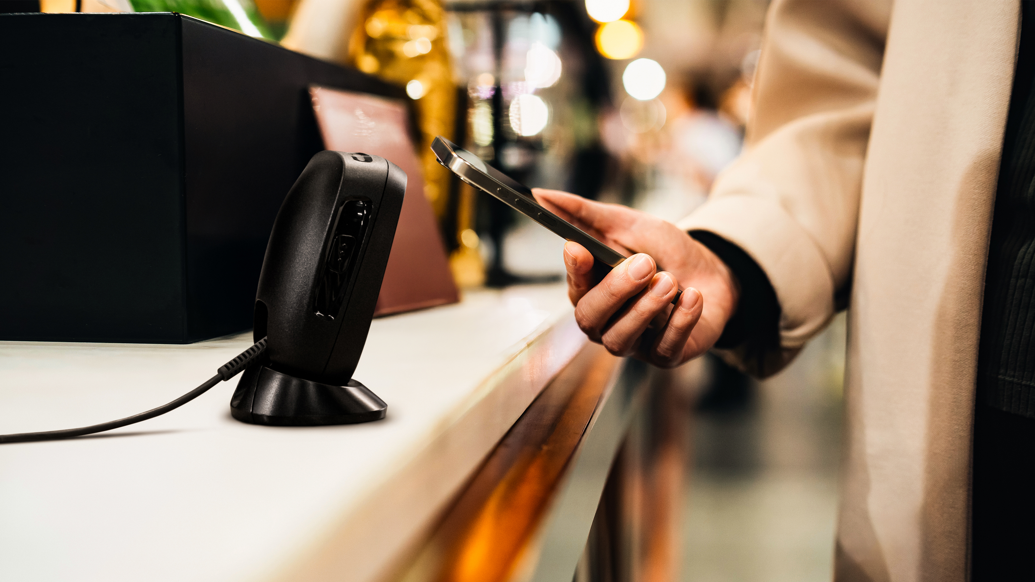 A shopper using tap-to-pay at checkout inside of a retail store.